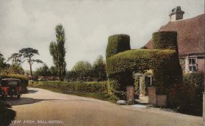 View of old house with yew arch over gate